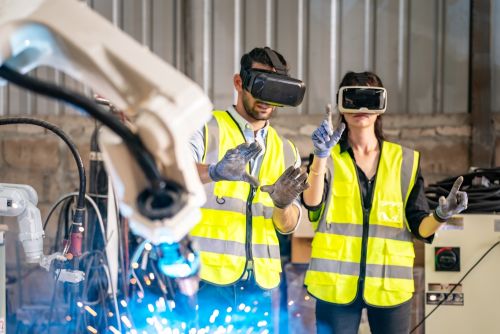a man and woman using VR headsets to learn about a manufacturing process